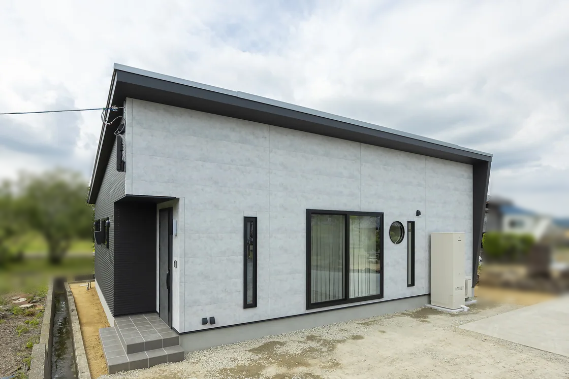 淡いグレーの外壁と黒い屋根の平屋住宅の外観